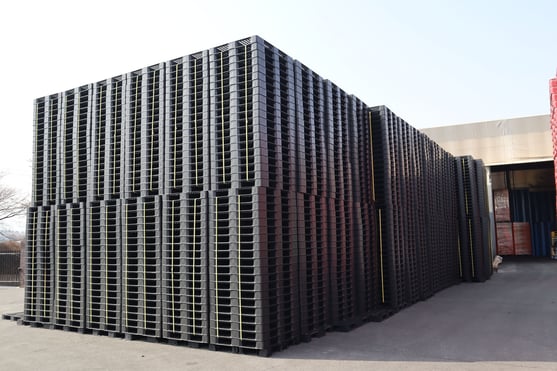 Tarimas plásticas en un contenedor iluminado, listas para exportación
